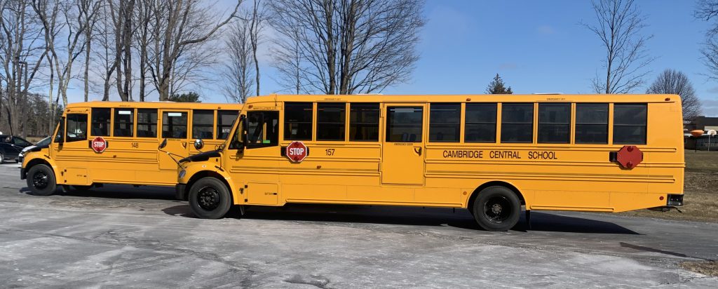 Two Cambridge school buses parked outside