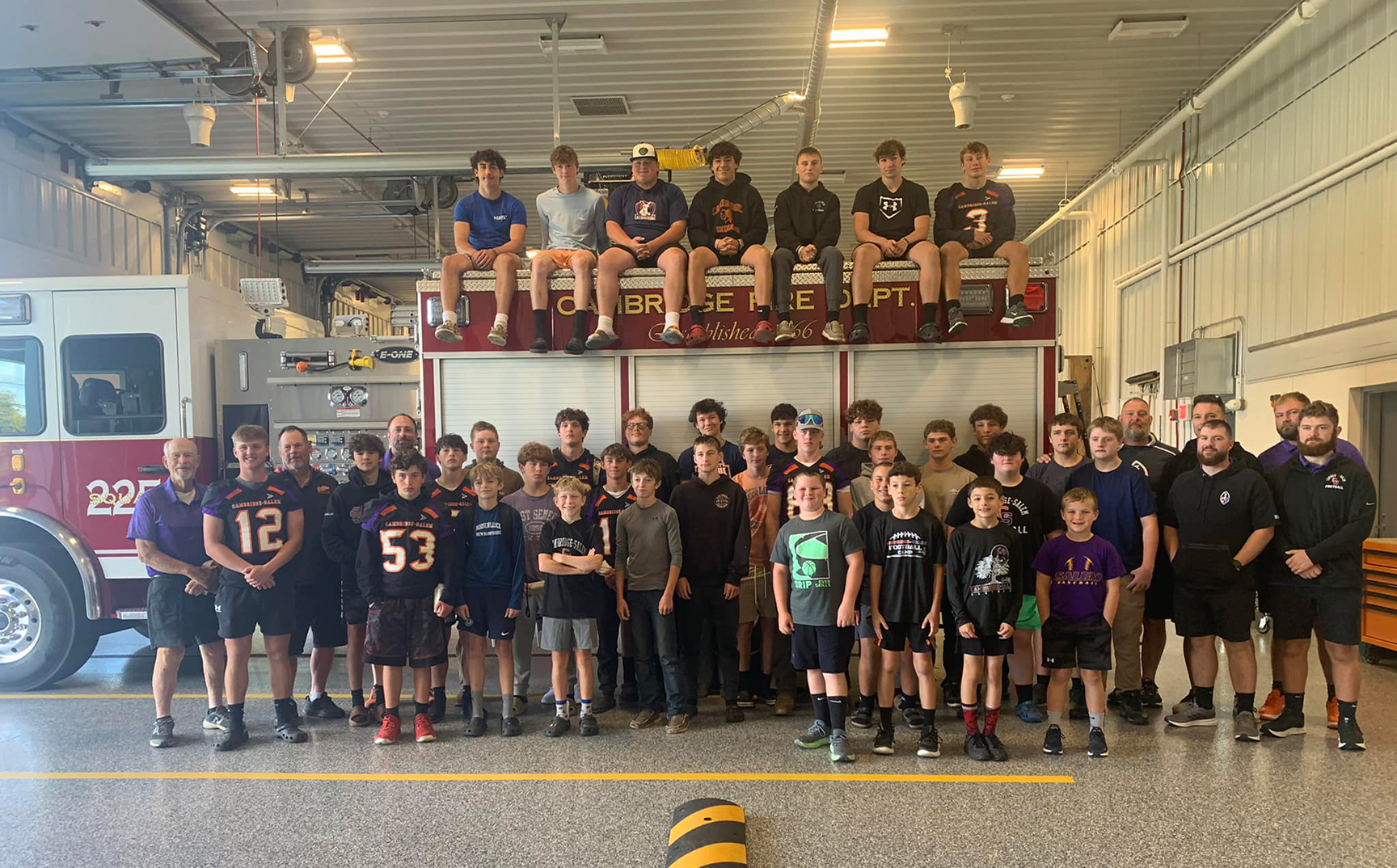 Football team and youth football players at the Fire House with the Cambridge Fire Department